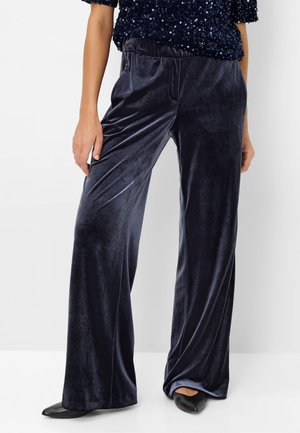 Wide-leg pants in navy blue velvet, featuring a stretchy waistband and smooth texture. Paired with black pointed-toe flats.