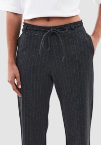 Donkergrijze pinstripe broek met een elastische tailleband en trekkoord, voorzien van zijzakken en een zachte, gestructureerde stof.