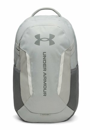 Grijze Under Armour rugzak met een handvat bovenaan, zijvakken van mesh en een verticaal logo op het voorpaneel.