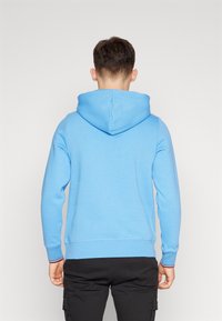 Felpa con cappuccio azzurro chiaro in misto cotone, con cappuccio regolabile, maniche lunghe e polsini a coste con un accento striato.