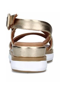 Sandali metallici dorati con una fascia larga, fibbia regolabile e soletta imbottita. Presenta una suola bianca con accenti marrone chiaro.