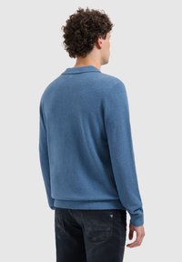 Blauwe fleece trui met een kraag en lange mouwen. Heeft een gestructureerd oppervlak en ribgebreide manchetten en onderrand.