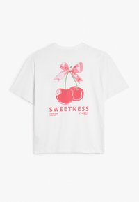 Witte katoenen t-shirt met een roze kers grafische afbeelding met een strik, en de tekst "ZOETHEID FRIS EN KOEL CHERRY BOMB" eronder.