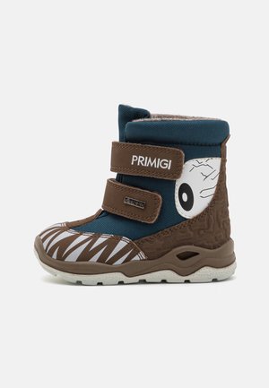 Botte d’hiver enfant en marron et bleu sarcelle foncé avec motifs zigzag blancs et graphisme œil, deux bandes velcro étiquetées Primigi et Gore-Tex.