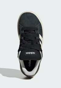 Baskets en daim noir avec des accents blancs. Comprend des lacets noirs, une languette texturée et un col rembourré. Logo affiché sur la languette et le talon.