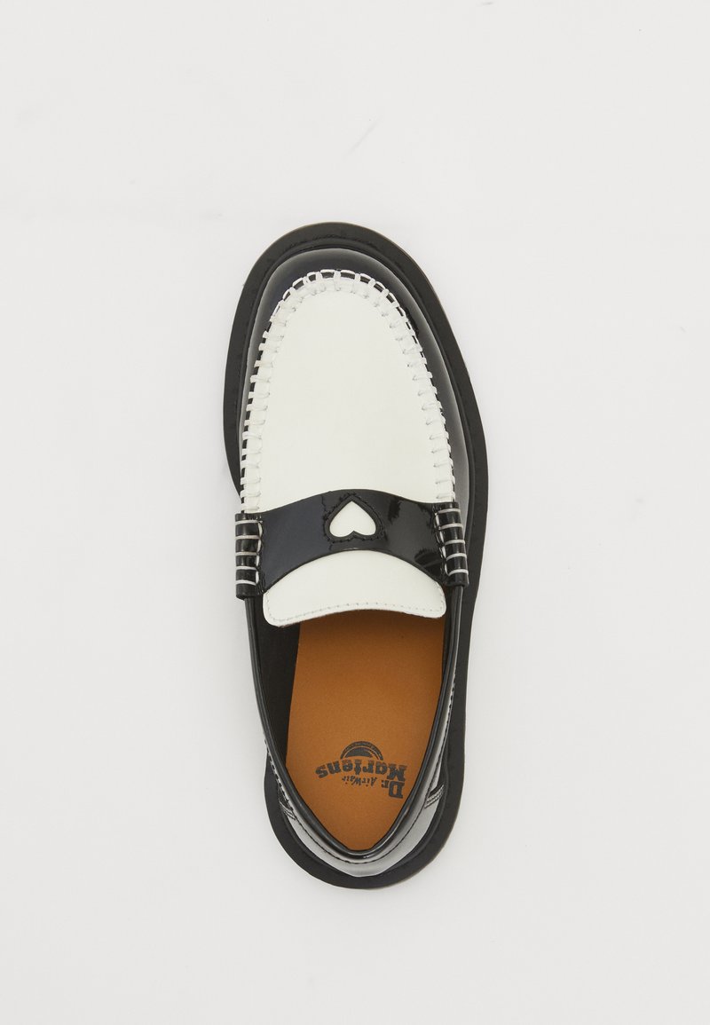 Loafer noir et blanc avec une découpe en forme de cœur sur la sangle, semelle intérieure beige et logo de la marque visible à l'intérieur, présenté sur un fond blanc.