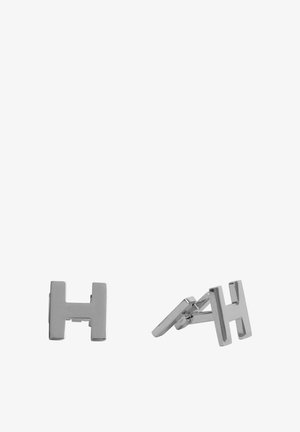 Gemelos de metal plateado con un diseño geométrico en forma de "H". Textura suave y acabado pulido, con un cierre articulado para un uso seguro.