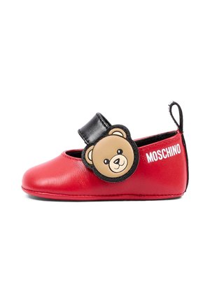 Chaussure bébé rouge avec une bride noire présentant un visage d'ours en peluche et un logo MOSCHINO blanc sur le côté, avec une boucle noire au talon.