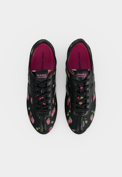 Paire de baskets noires Marc Jacobs avec motifs floraux roses et semelles intérieures rose vif, vues de dessus sur fond blanc.