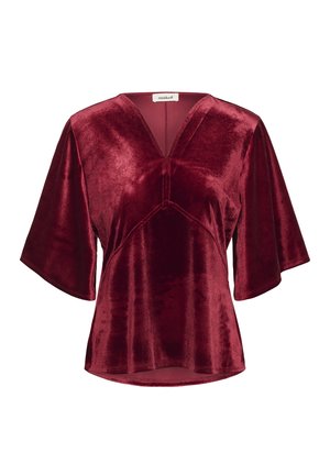 Top in velluto di un profondo bordeaux con scollatura a V, maniche corte ampie e orlo curvo. Texture morbida con una leggera lucentezza.