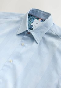 Svetlomodrá pánska košeľa s jemným kockovaným vzorom, kvetinovou vnútornou podšívkou goliera a dvoma viditeľnými gombíkmi, označená veľkosť M.