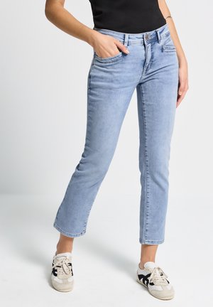 Jeans en denim bleu clair avec une coupe droite, cinq poches et une fermeture éclair. Présente une légère décoloration et des détails matériels minimaux.