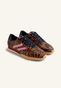Sneaker a strisce tigerate con una combinazione di colori marrone e nero, caratterizzati da accenti rosa, lacci neri e una suola in gomma texturizzata.