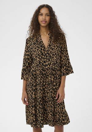 Jurk met luipaardprint in bruin en zwart. Heeft een V-hals, driekwart mouwen en een geplooide rok met verschillende lagen. Gemaakt van lichtgewicht stof.