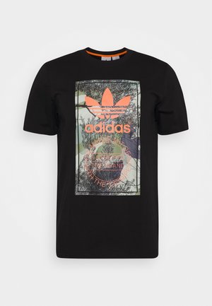 Schwarzes Adidas T-Shirt mit orangefarbenem Logo und Text über einer naturinspirierten Grafik auf der Vorderseite.