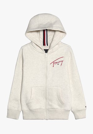 Jasnobeżowa bluza z kapturem na zamek błyskawiczny, z przednimi kieszeniami, czerwonym haftem napisu "Tommy" na piersi oraz czerwoną, białą i niebieską podszewką kaptura w paski.