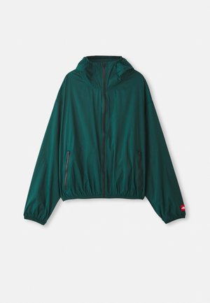 Chaqueta verde, ligera, con cierre de cremallera en la parte frontal, capucha ajustable, dobladillo elástico y dos bolsillos laterales. Presenta acentos de logo rojo en la manga.