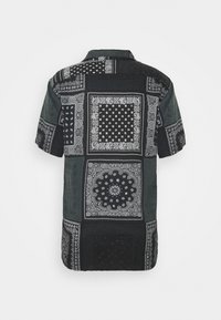 Camicia a maniche corte con un design a patchwork in nero e grigio, caratterizzata da complessi motivi paisley e geometrici. Tessuto morbido.