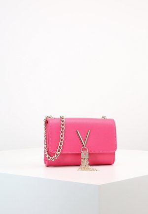 Clutch in pelle rosa acceso con tracolla a catena d’argento, impreziosito da una chiusura a forma di V argentata e dettagli con nappine su una superficie bianca.
