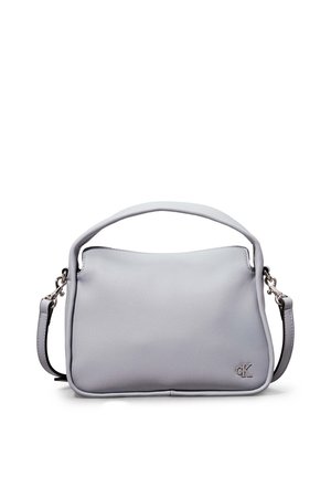 Sac à main en cuir souple gris clair avec poignée courte et bandoulière détachable, featuring petit logo argenté "CK" dans le coin inférieur avant.