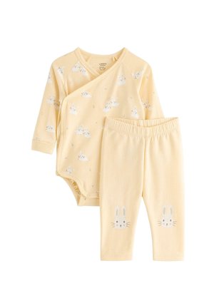 Gul langærmet babybody med hvide kaninprint og matchende bukser med kaninansigter på knæene.