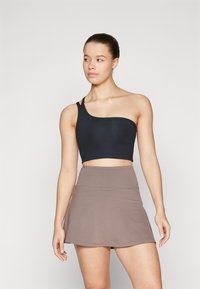 Top corto negro de un solo hombro con un diseño ajustado, combinado con una falda acampanada en color topo. Tejido liso y elástico; estilo minimalista.