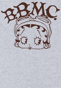 Tejido gris que presenta una cara de dibujos animados marrón con ojos grandes y una cinta para la cabeza, acompañada de letras marrones estilizadas "B.B.M.C." arriba.