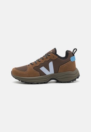 Brown and olive hiking shoe with mesh and suede materials, featuring a light blue logo, black laces, and a rugged, textured sole.