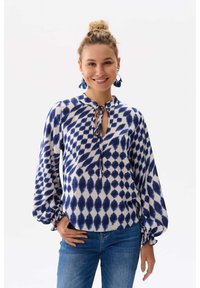 Blauw-witte gebloemde blouse met een keyhole halslijn, ballonmouwen en elastische manchetten, gemaakt van lichte stof.