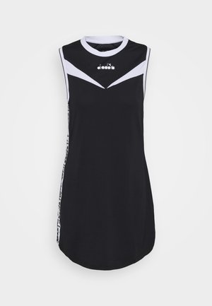 Robe noire sans manches avec des accents chevrons blancs sur la poitrine et les épaules, encolure ronde et logo centré sous le col.