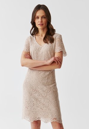 Abito in pizzo color beige chiaro a maniche corte con intricati motivi a spirale, scollatura a V e bordo ondulato, progettato per una silhouette aderente.