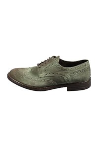 Scarpa brogue in camoscio verde con perforazioni decorative, punta arrotondata, lacci marroni e tacco impilato marrone scuro.