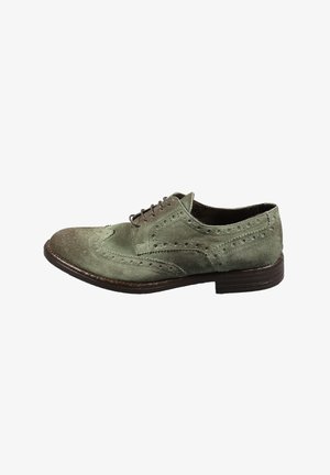 Scarpa brogue in camoscio verde con perforazioni decorative, punta arrotondata, lacci marroni e tacco impilato marrone scuro.