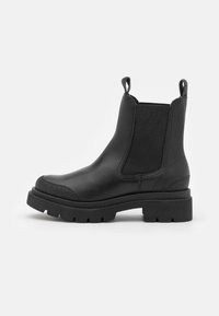 Botas de tobillo de cuero negro con paneles laterales elásticos, puntera redonda, frente texturizado, lengüetas de tirón y suelas de goma gruesa.