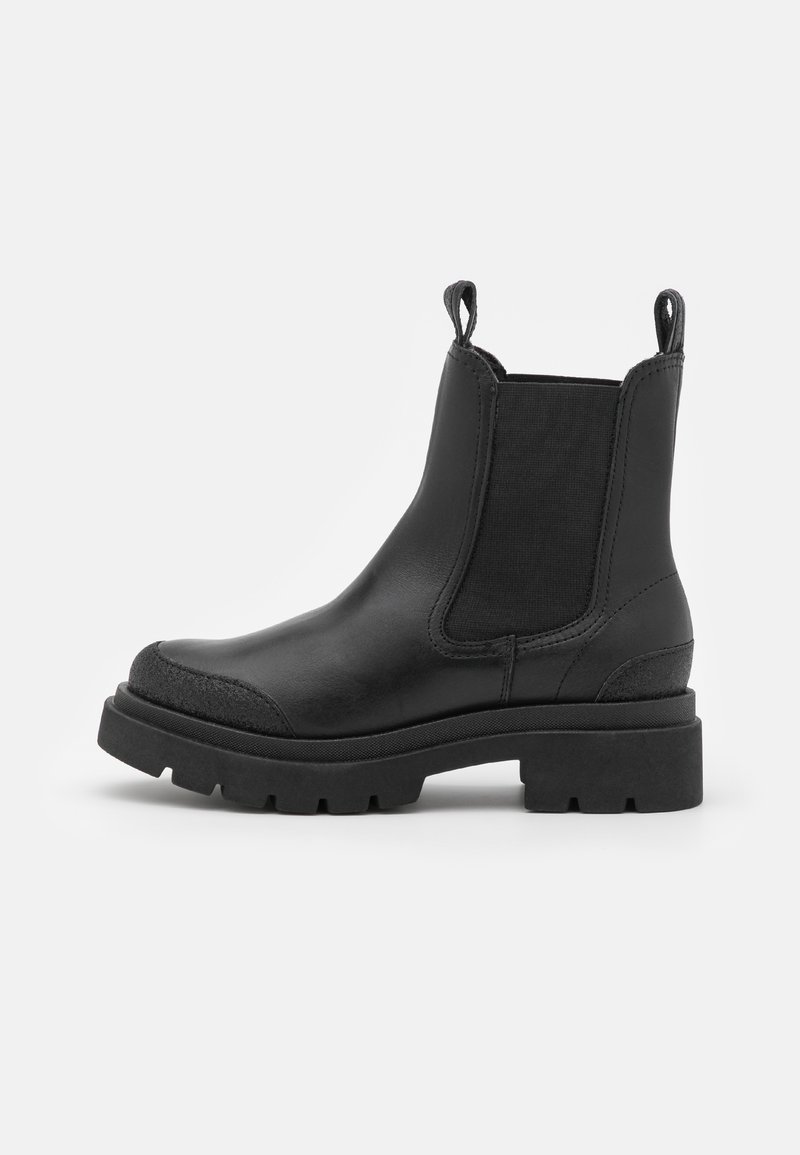 Botas de tobillo de cuero negro con paneles laterales elásticos, puntera redonda, frente texturizado, lengüetas de tirón y suelas de goma gruesa.