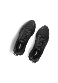 Zapatillas deportivas negras con tejido texturizado, diseño con cordones, puntera reforzada y suela de goma. Presentan un logo en la plantilla y acentos en contraste.