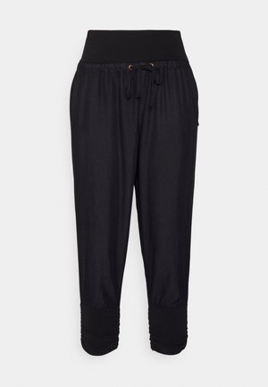Zwarte cropped broek van lichtgewicht stof. Kenmerkt zich door een brede elastische tailleband met trekkoord en geplooide details bij de mouwen.