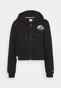 Sudadera corta negra de algodón, con cremallera frontal, bolsillo tipo canguro y logo blanco de "Tommy" en el pecho.