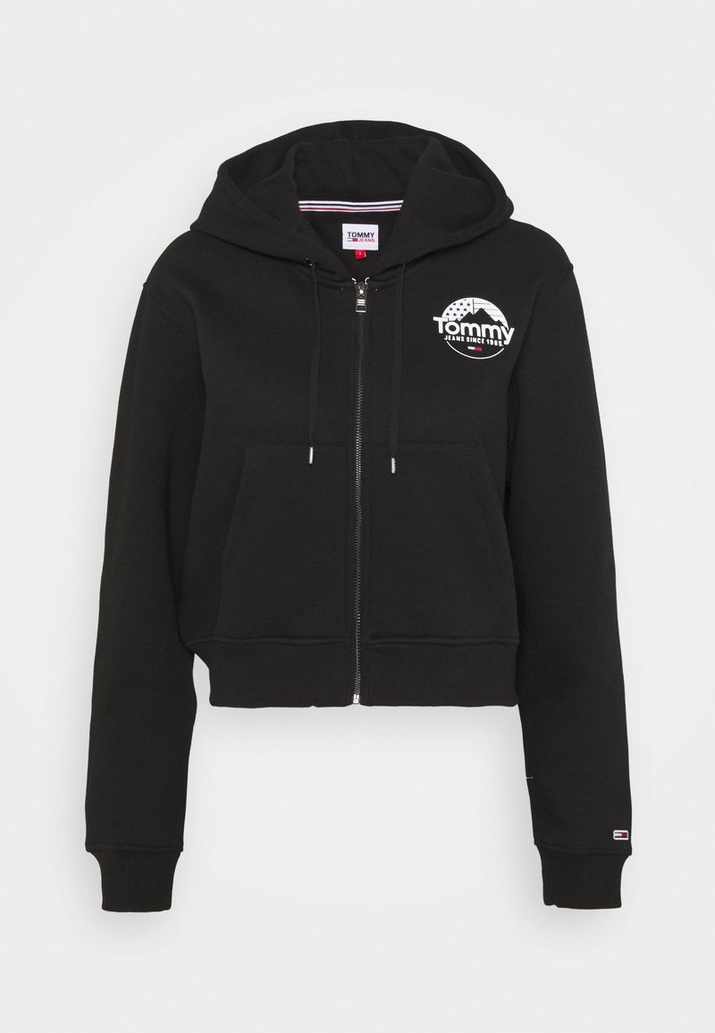 Sudadera corta negra de algodón, con cremallera frontal, bolsillo tipo canguro y logo blanco de "Tommy" en el pecho.