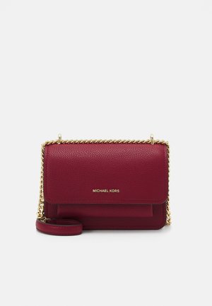 Kleine bordeauxrode leren crossbodytas met textuur, gouden kettingriem en "Michael Kors"-logo op de voorslag.