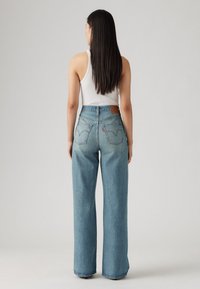Lichtblauwe denim wide-leg jeans met een hoge taille, met achterzakken en een leren bruin label bij de tailleband.