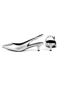 Srebrne metalne slingback pete s špičastim nosom, ki imajo vitko peto in nastavljiv pas s podrobnostmi v obliki okrogle zaponke.