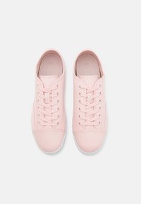 Pink canvas sneakers with a rounded toe, lace-up design, and textured rubber sole. Smooth finish with matching laces and minimal accents.