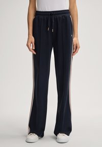 Marineblauwe sweatpants van zachte stof, met zijstrepen in het wit en rood, elastische tailleband met een trekkoord en een losse pasvorm.