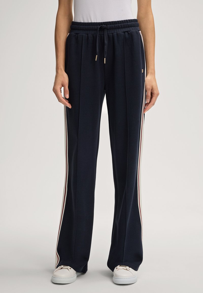 Marineblauwe sweatpants van zachte stof, met zijstrepen in het wit en rood, elastische tailleband met een trekkoord en een losse pasvorm.