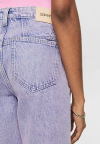 Jeans de mezclilla color lila claro con corte recto, con una etiqueta blanca de ESprit en la cintura y un detalle en el bolsillo trasero.