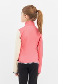 Roze en roomkleurige zip-up jack met een hoge kraag, lange mouwen en gestreepte zoom. Glad textuur met een getailleerd ontwerp.