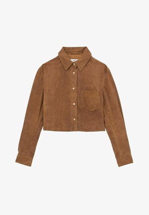 Chemise en daim marron raccourcie avec un col pointu, une poche avant et des boutons métalliques. Texture lisse avec des manches longues et une coupe ajustée.
