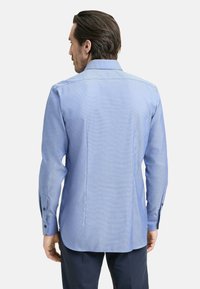 Camicia button-up a scacchi blu con maniche lunghe, retro dritto e polsini con bottoni. Tessuto in cotone misto con una texture liscia.