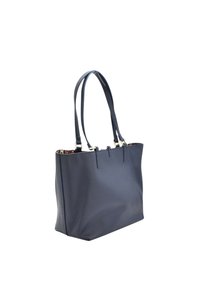 Granatowa skórzana torba na ramię z dwoma paskami, gładka tekstura, otwarta góra, wewnętrzna podszewka w wzory oraz złote akcenty.